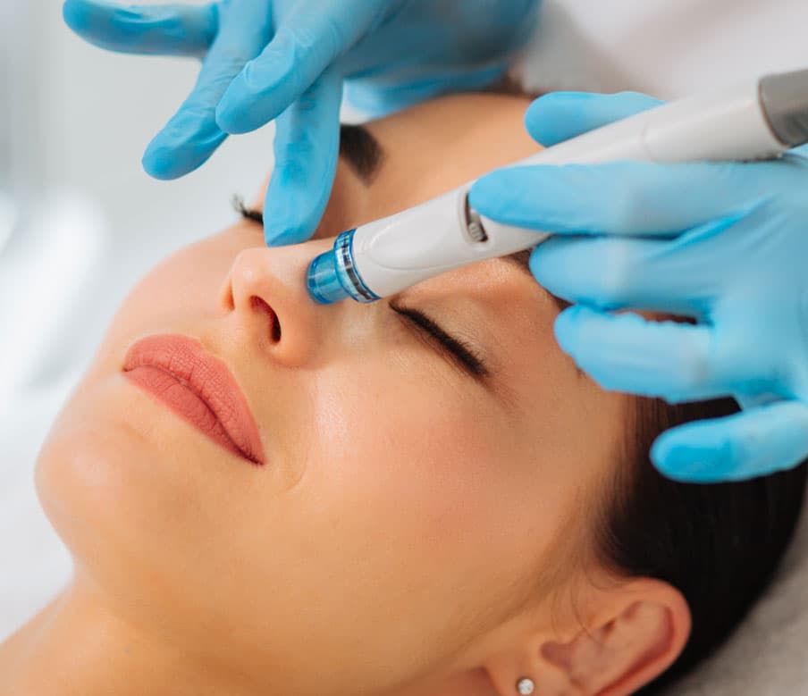 Utiisation de la machine hydrafacial sur le visage d'une femme pour un soin