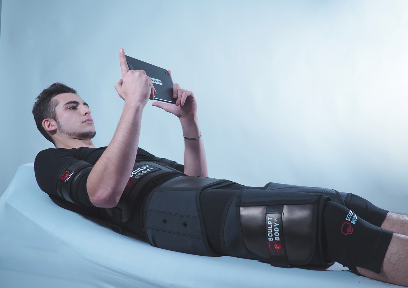 Personne allongée qui gère la machine depuis son écran tactile